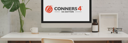A computer on a desk with the Conners 4 logo displayed on the computer screen.