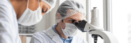 A doctor looking into a microscope.