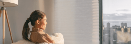 A woman relaxing at home and looking out the window.